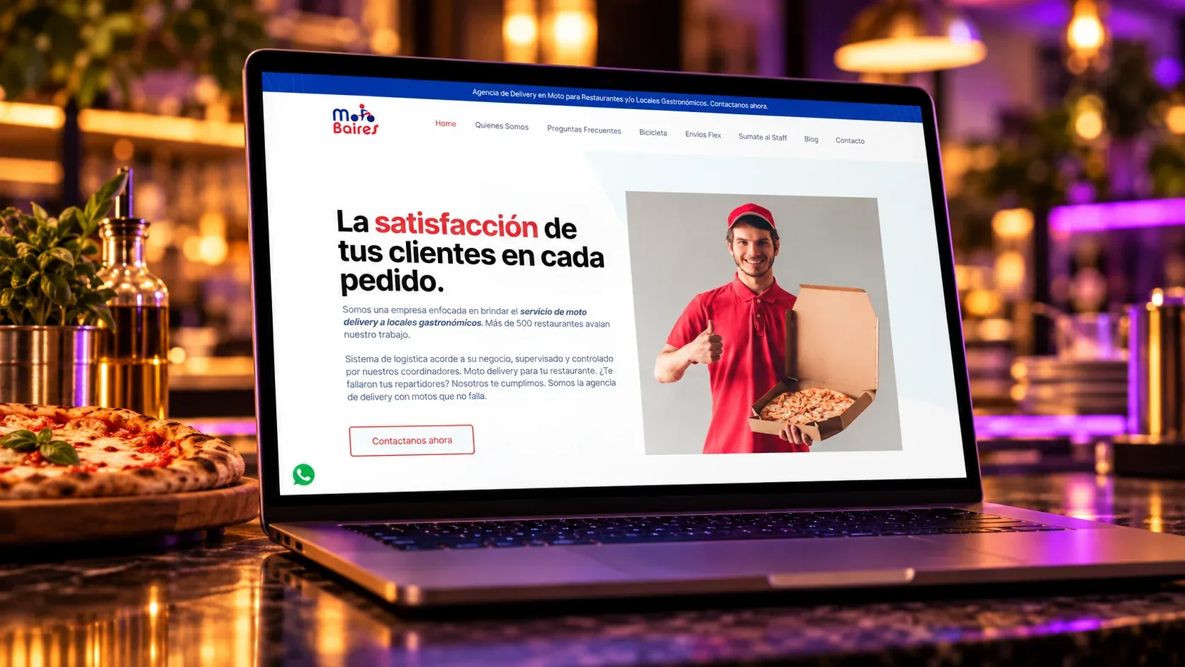 Sitio web de MotoBaires mostrado en una laptop junto a una pizza